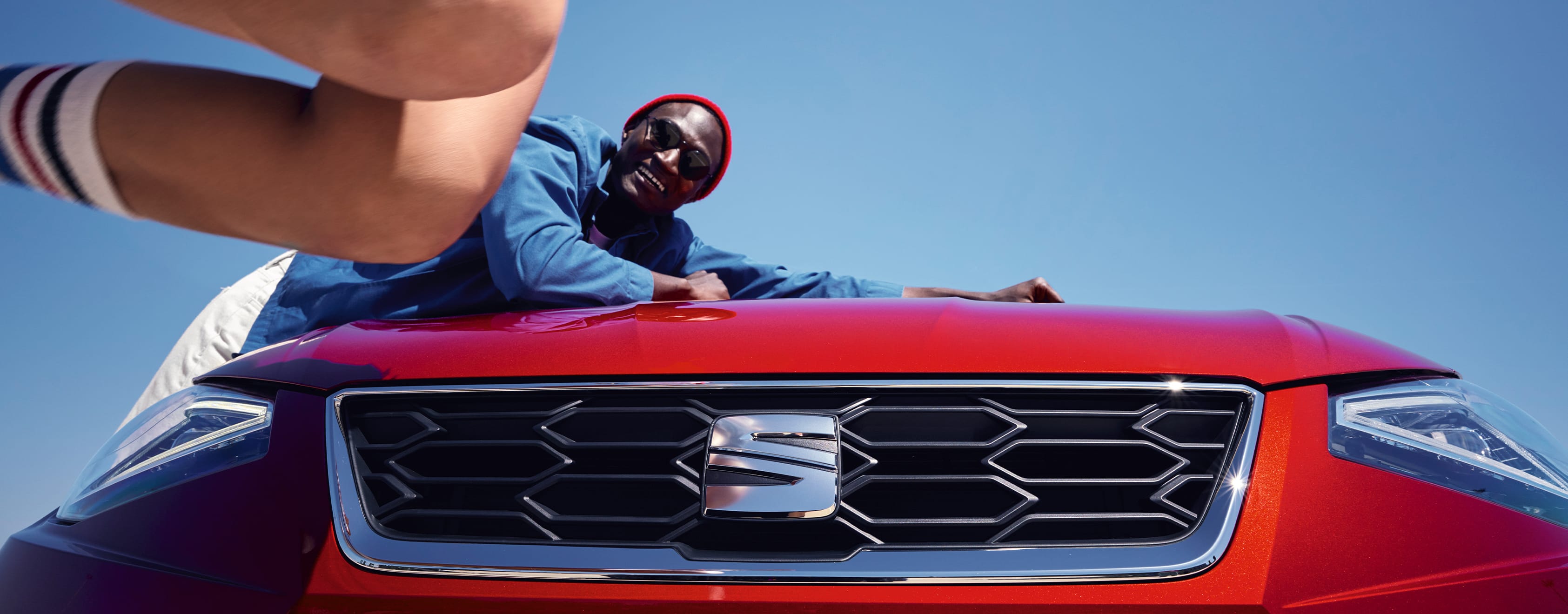 Man leaning on SEAT Ibiza's bonnet desire red colour 