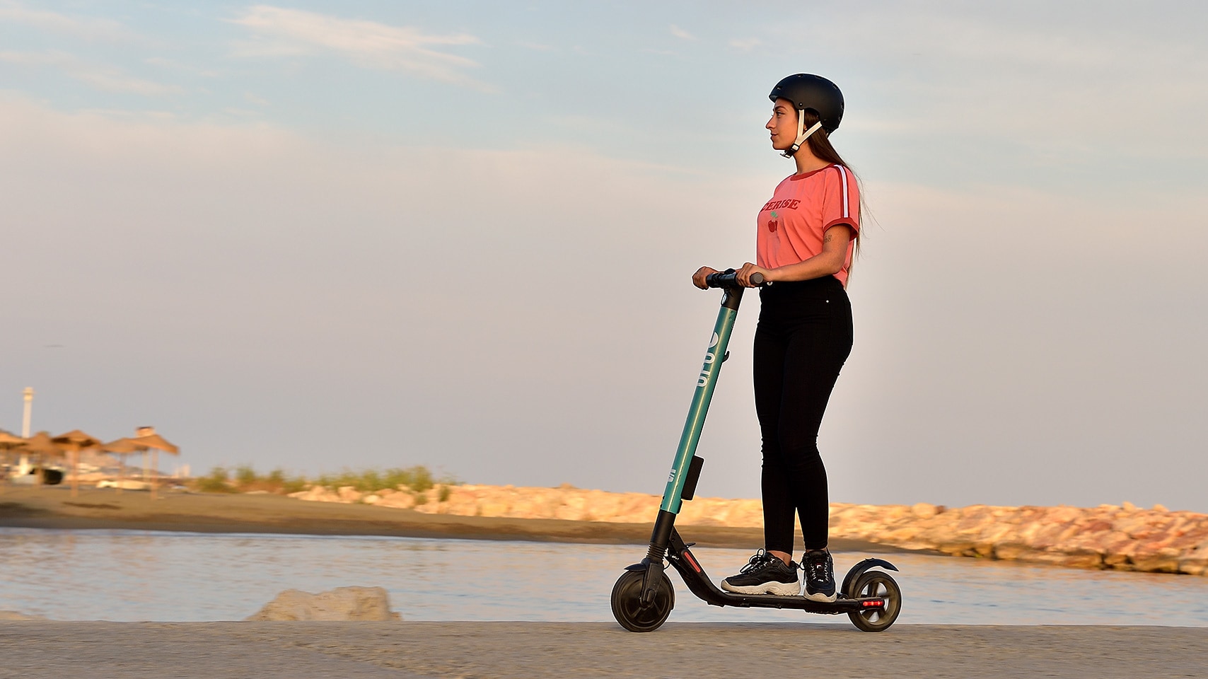 A woman riding a SEAT eXs during the sunset