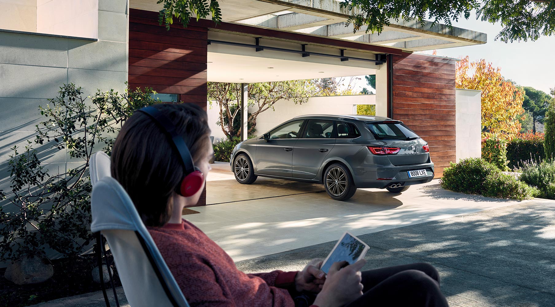 SEAT Leon Sportourer ST parked at home with woman watching in a relaxed scene