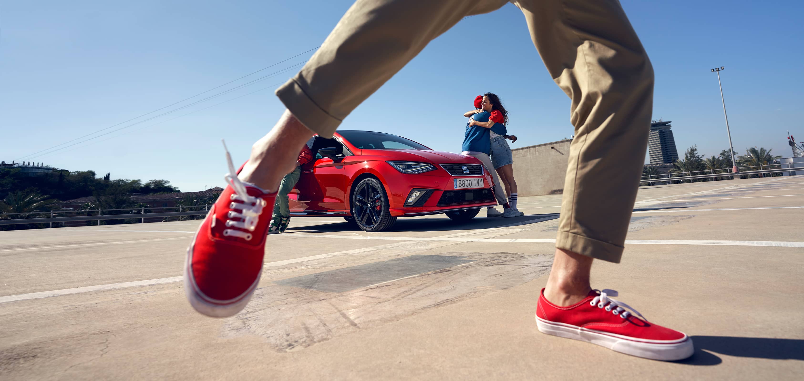 Man, dancing in front of SEAT Ibiza desire red colour  and couple hugging